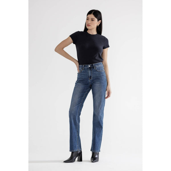 Woman wearing straight leg full  length jeans and a black t-shirt on a white background