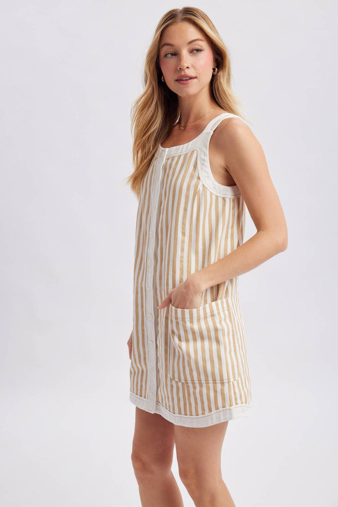 Woman wearing a striped dress with pockets on a white background showing side view.