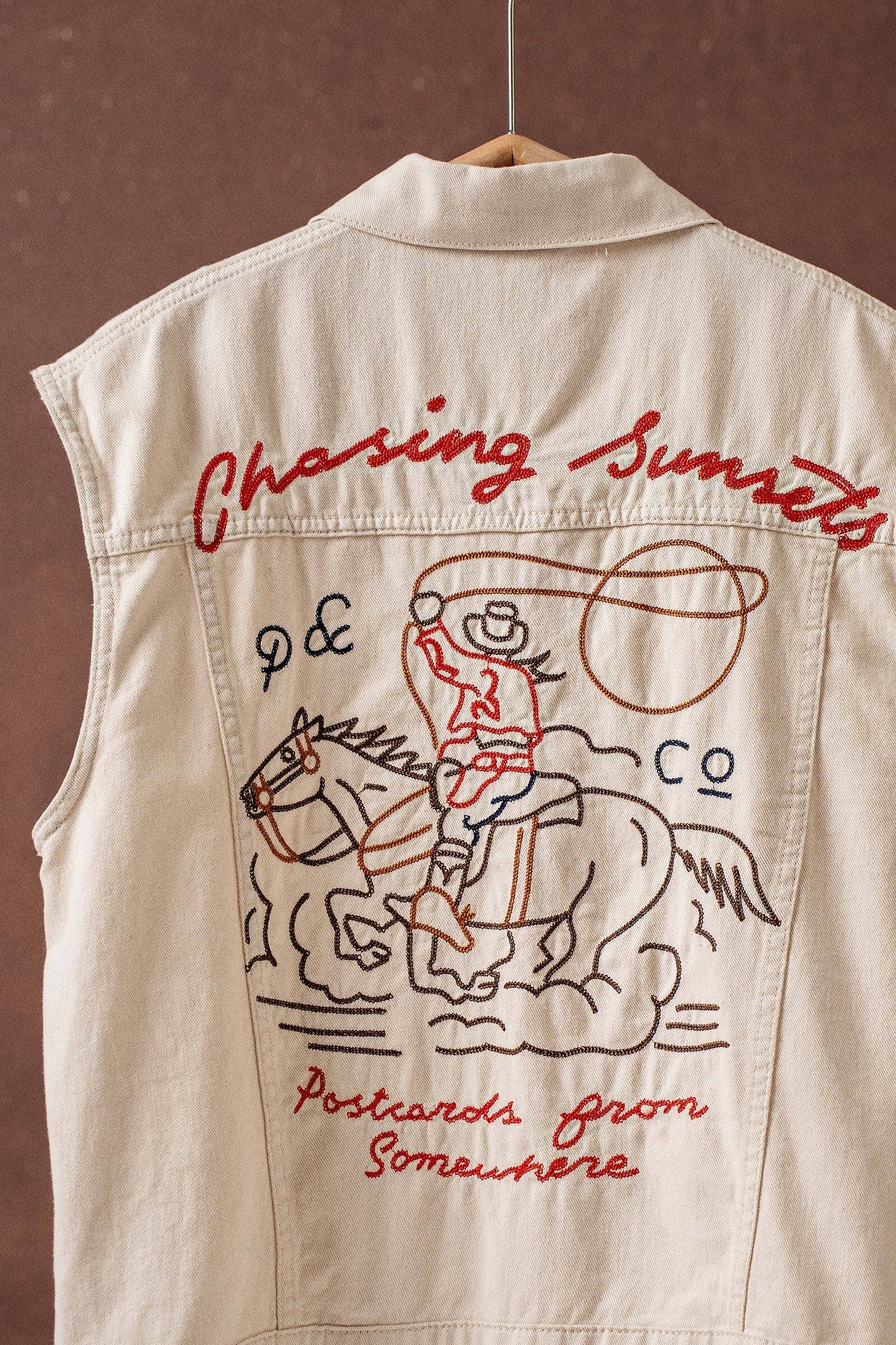 Beige vest with red embroidered design of a cowboy on a horse and text.