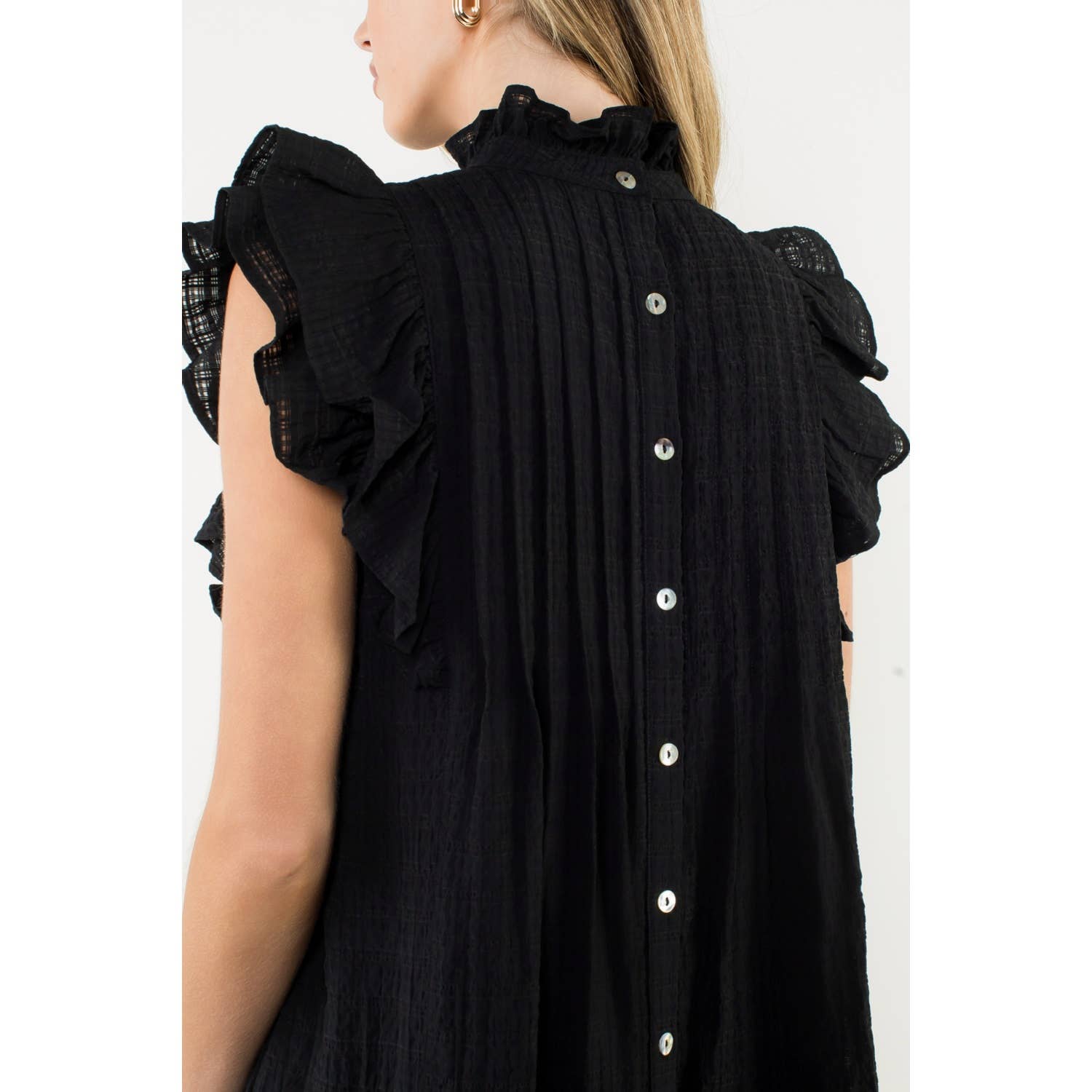 Black ruffled blouse with buttons on a white background
