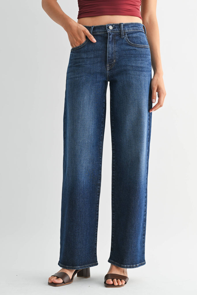 Person wearing blue jeans on a plain background. Front view.