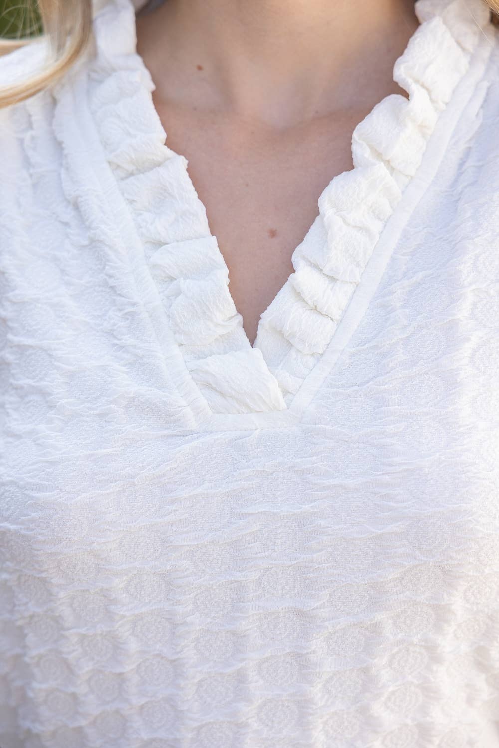 Close-up of a white textured garment with a blurred background