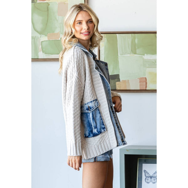 Woman wearing a cardigan with denim accents in a room with abstract art on the wall.