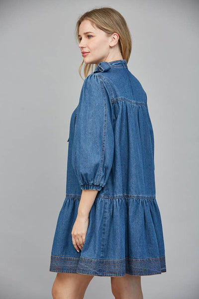 Women in denim dress with three quarter sleeves showing side view.