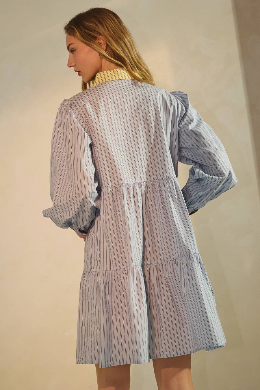 Woman wearing a striped dress with a plain background