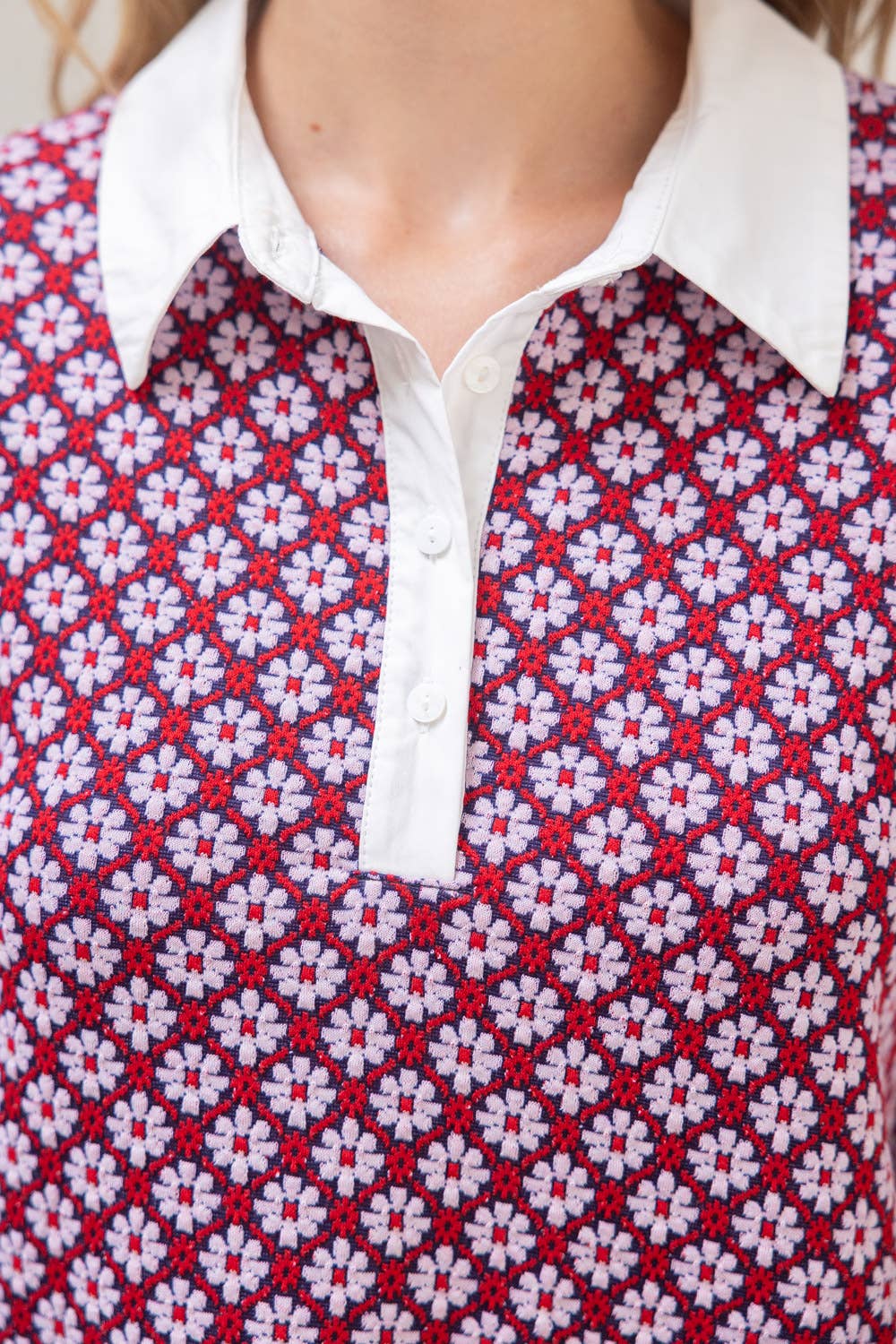 Close-up of a red and white patterned shirt with a white collar.