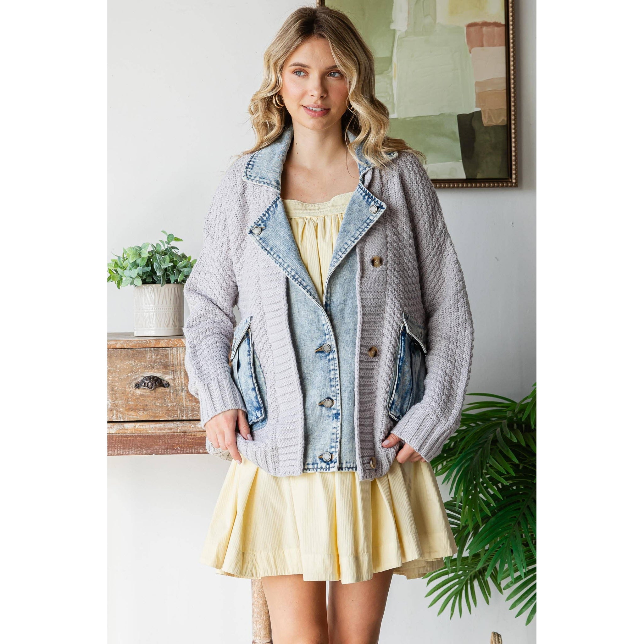 Woman wearing a yellow dress layered with a cream and denim  jacket. Front styling view.