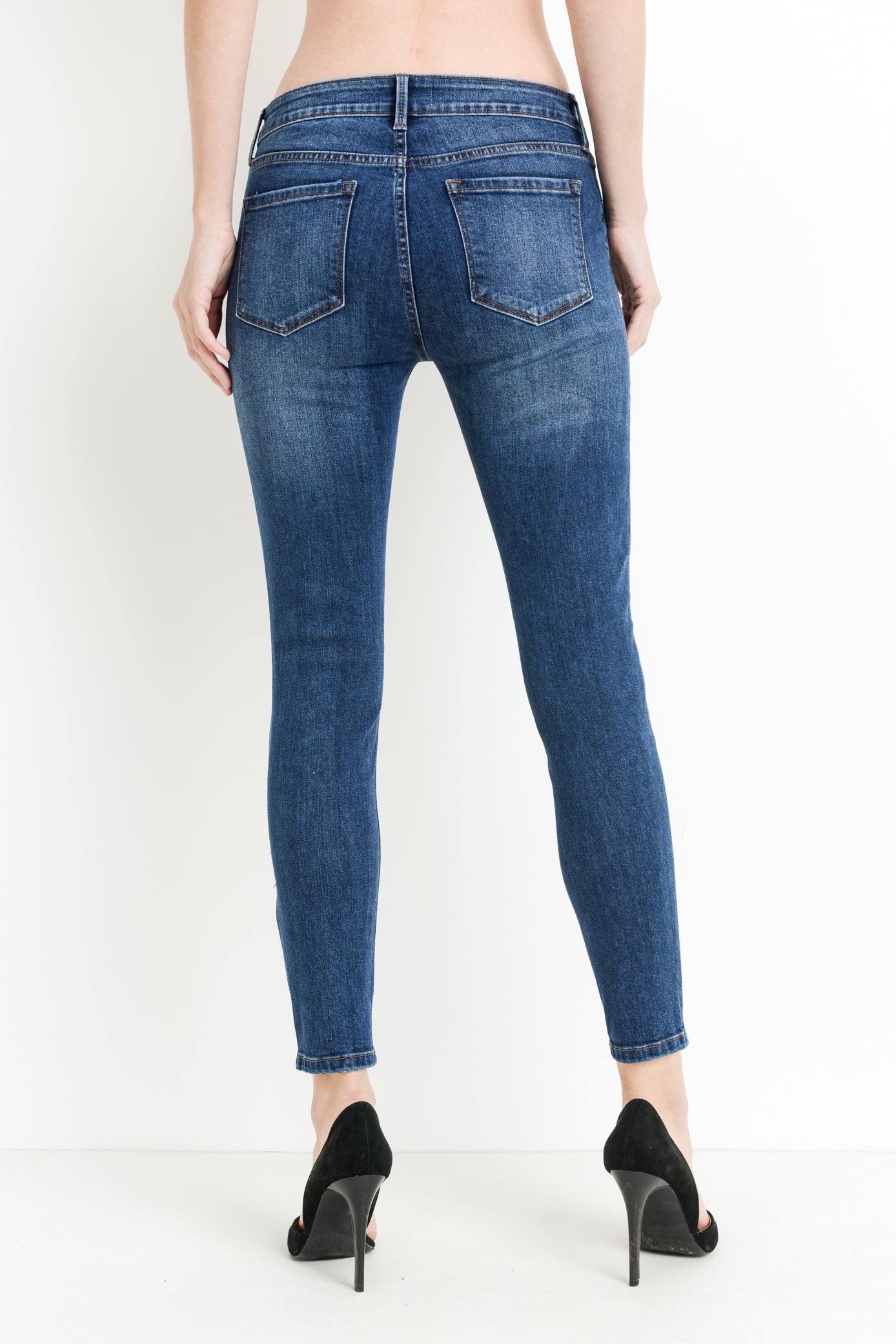 Mid rise dark denim skinny jeans with distressing